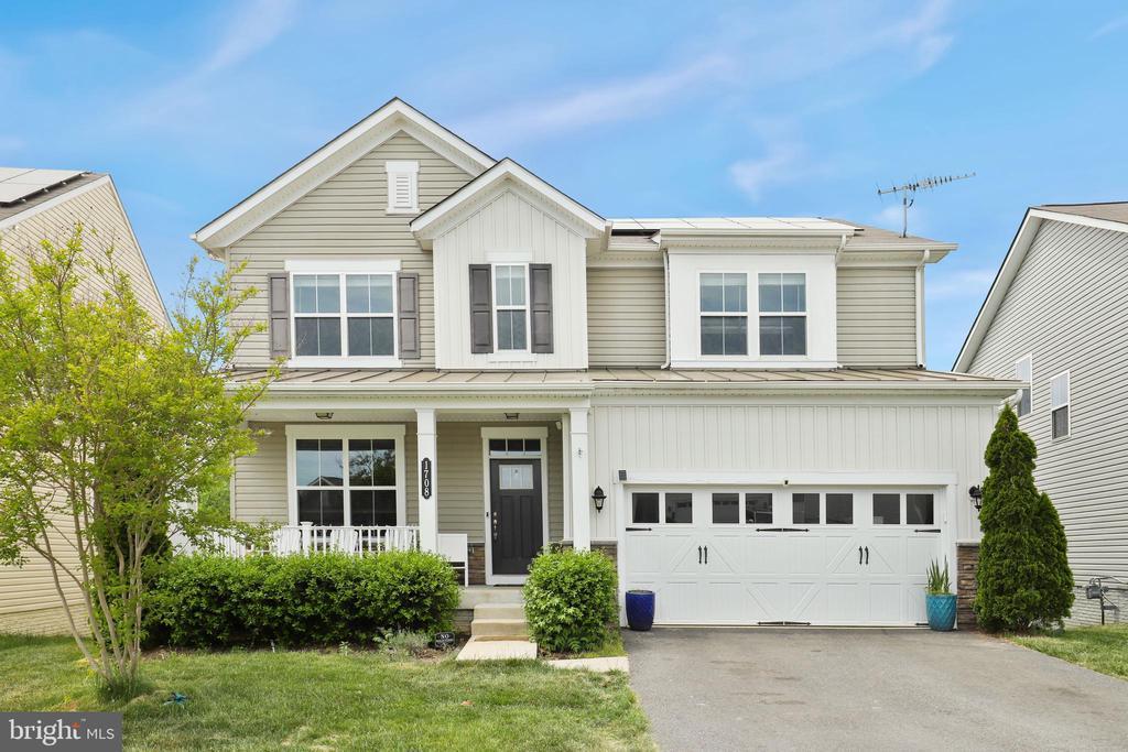 1708 Hudgins Farm Cir, Fredericksburg, VA 22408 - traditional-style home featuring a porch, an attached garage, asphalt driveway, board and batten siding, and a standing seam roof