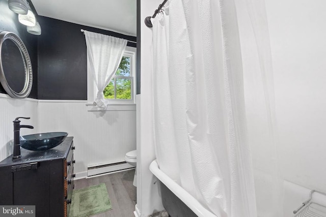 404 N Franklin St, Remington, VA 22734 - full bath featuring a baseboard heating unit, wood finished floors, vanity, wainscoting, and shower / bath combo