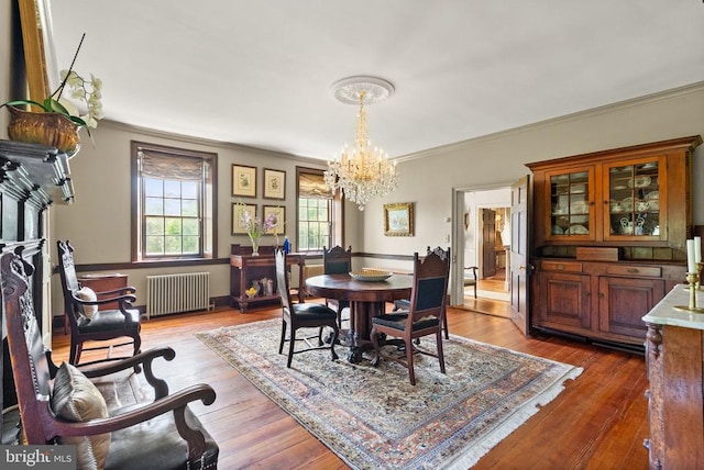  - dining room with radiator heating unit, a chandelier, ornamental molding, and wood-type flooring