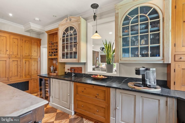  - kitchen with wine cooler, ornamental molding, glass insert cabinets, decorative light fixtures, and dark countertops