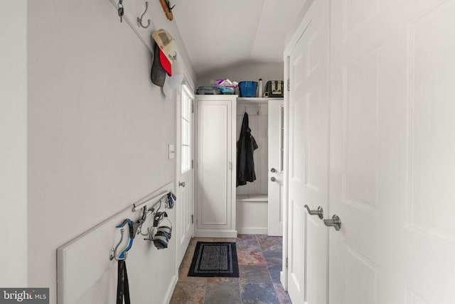  - hall featuring lofted ceiling and stone finish flooring