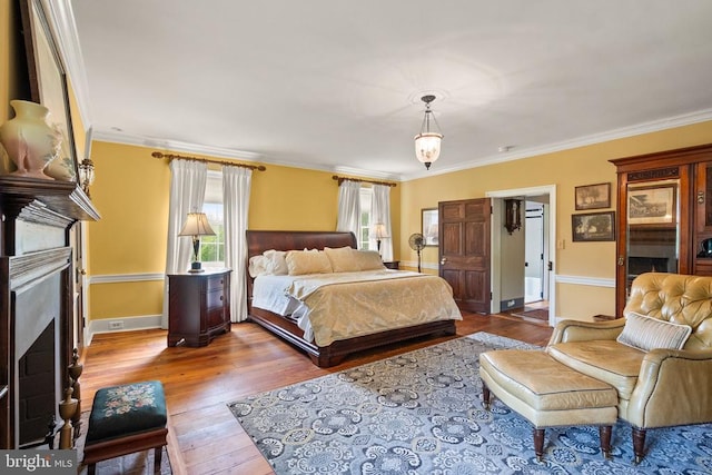  - bedroom with a fireplace, hardwood / wood-style floors, and crown molding