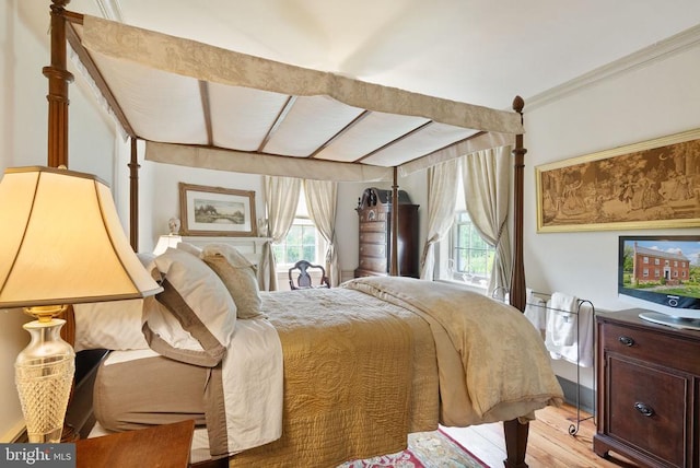  - bedroom featuring light wood-style flooring and crown molding
