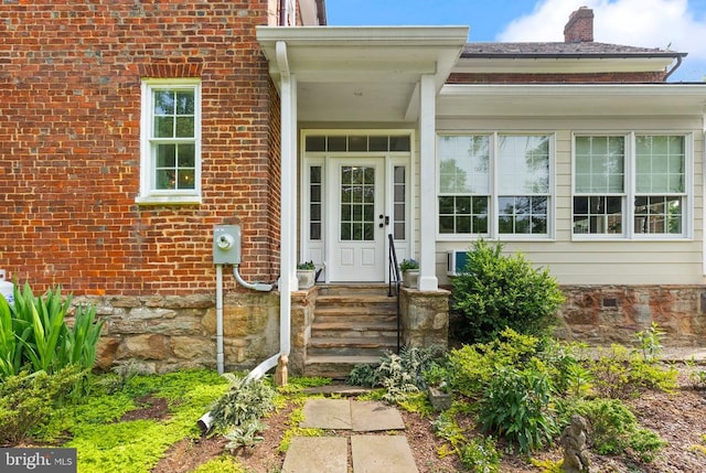  - entrance to property featuring a chimney and brick siding