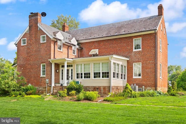  - rear view of house featuring a chimney, a yard, brick siding, and a high end roof