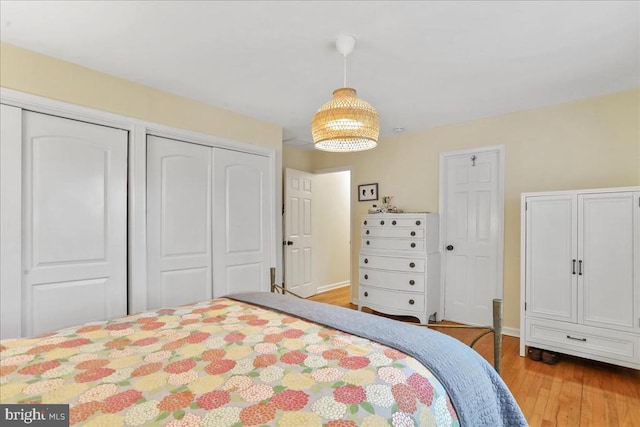  - bedroom with wood finished floors and two closets