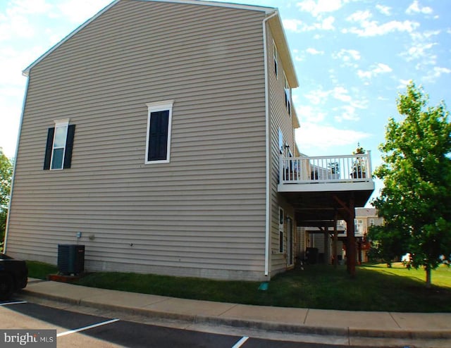  - view of side of property featuring a yard and a central air condition unit
