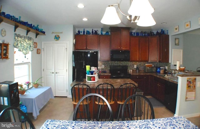  - kitchen featuring black appliances, dark countertops, decorative backsplash, pendant lighting, and recessed lighting