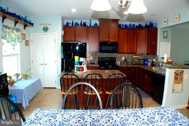  - kitchen with black appliances, tasteful backsplash, dark countertops, a kitchen island, and a kitchen bar