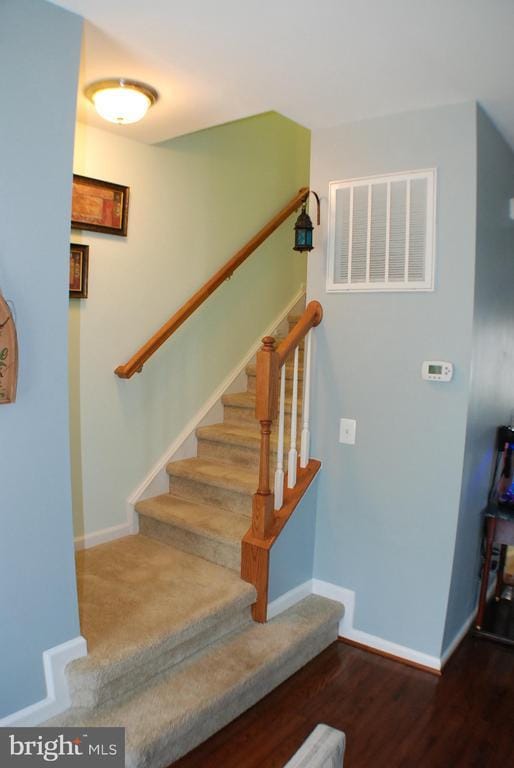  - stairs with baseboards and wood finished floors