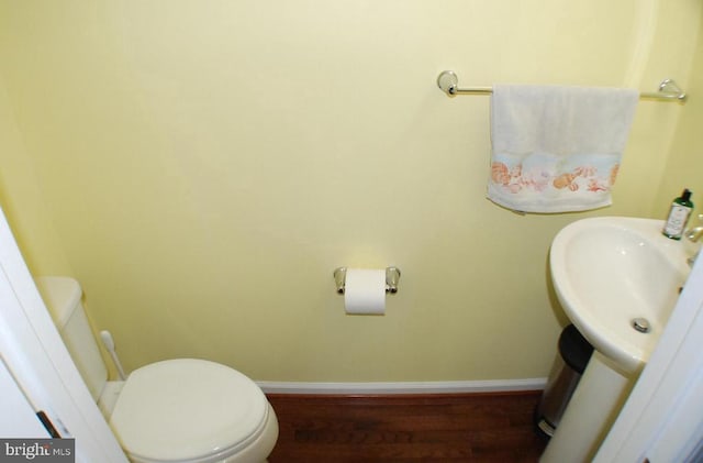  - half bathroom with baseboards and wood finished floors