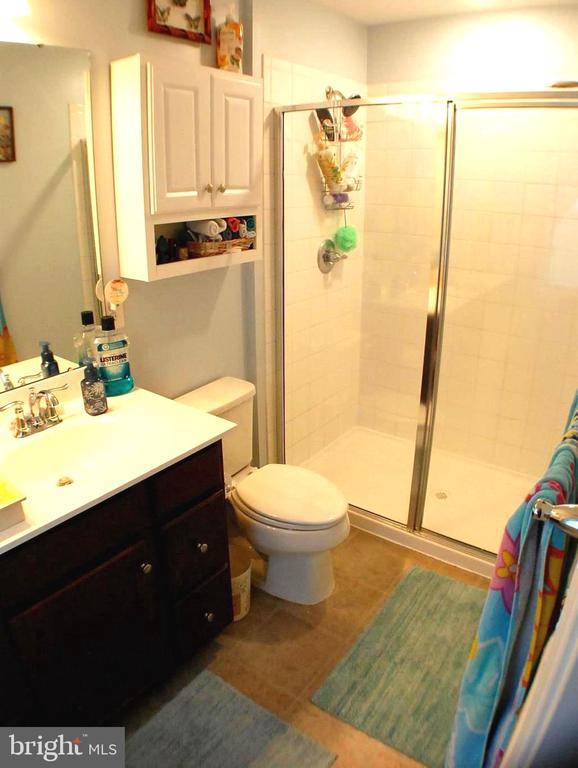  - bathroom featuring vanity, a shower stall, and tile patterned flooring