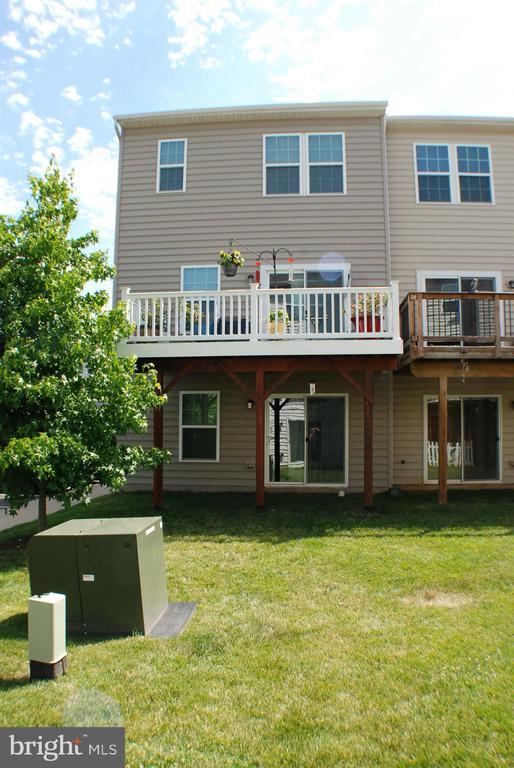  - rear view of house with a yard and a wooden deck