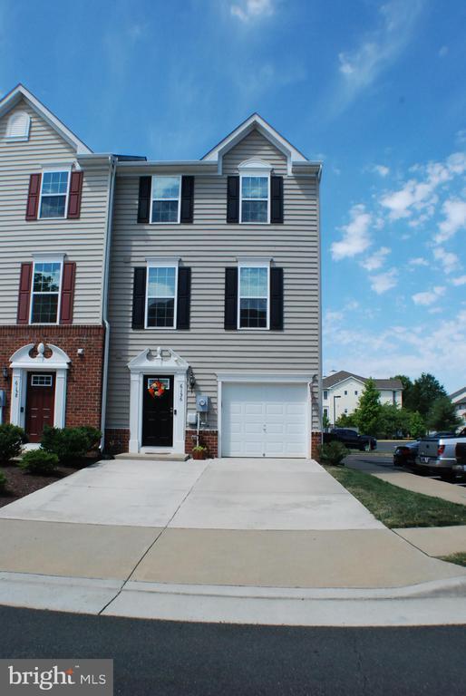 - view of front of property featuring driveway, an attached garage, and brick siding