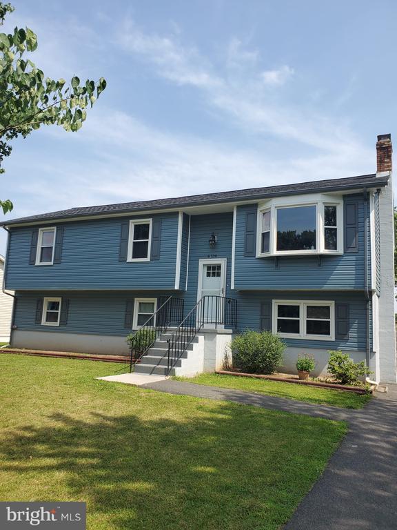 - raised ranch with a front yard and a chimney