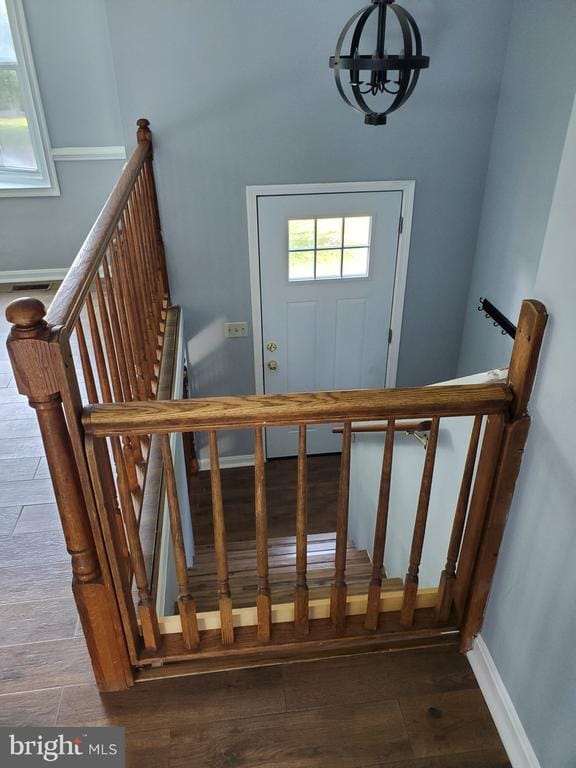  - staircase with a chandelier and wood finished floors