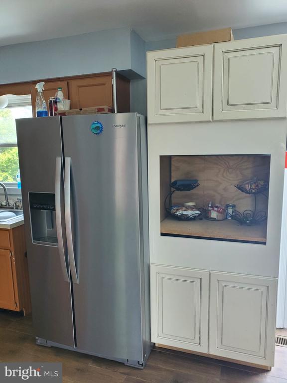  - kitchen featuring stainless steel fridge with ice dispenser and dark wood finished floors