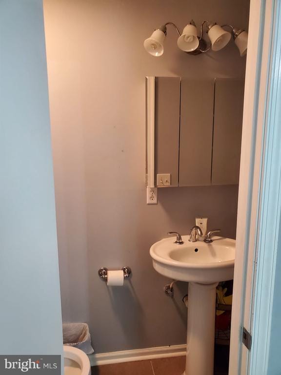  - half bathroom with tile patterned floors and baseboards