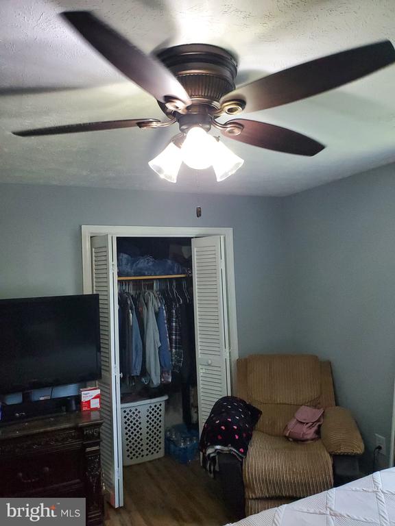  - bedroom with wood finished floors, a closet, and a ceiling fan