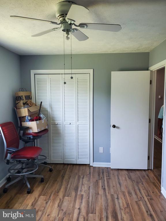  - bedroom with a closet, wood finished floors, ceiling fan, and a textured ceiling