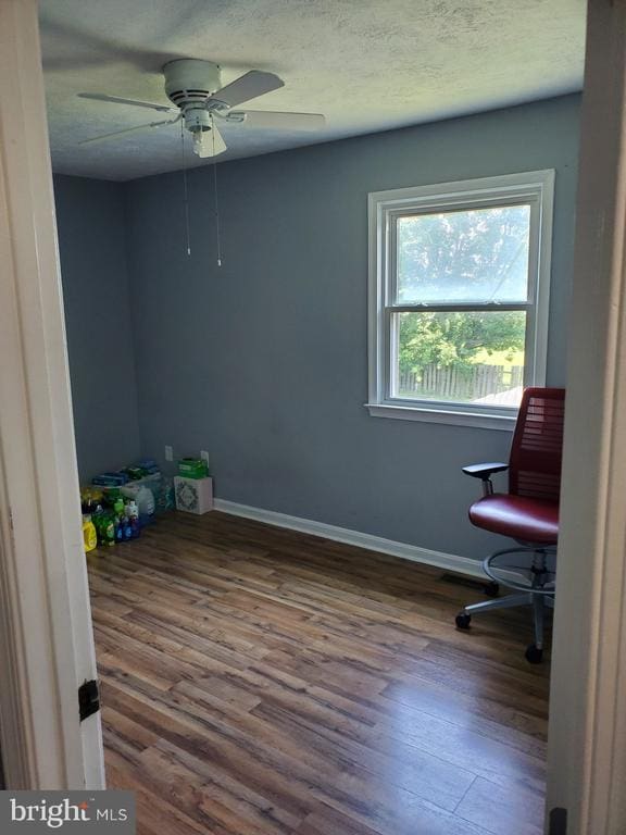  - unfurnished office featuring wood finished floors, ceiling fan, and a textured ceiling