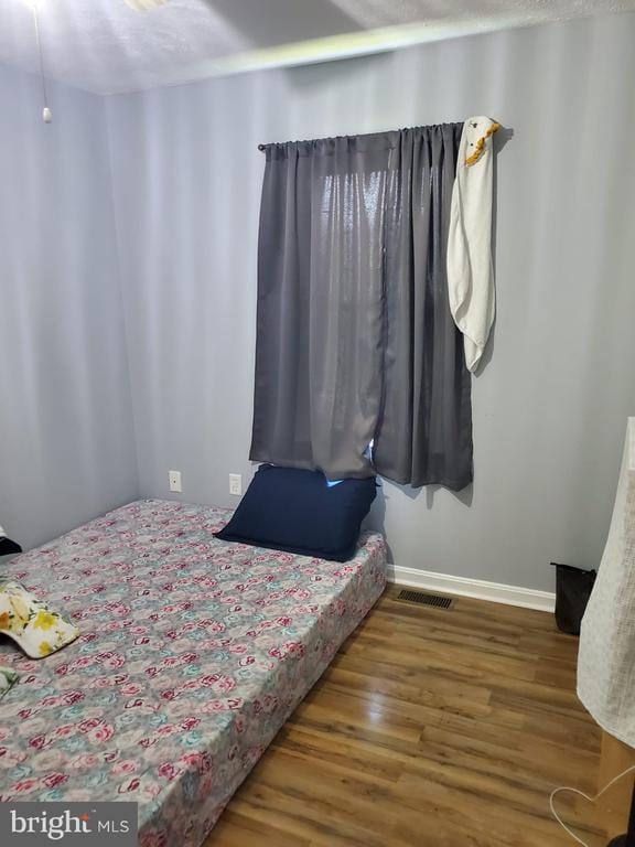  - bedroom featuring wood finished floors and baseboards