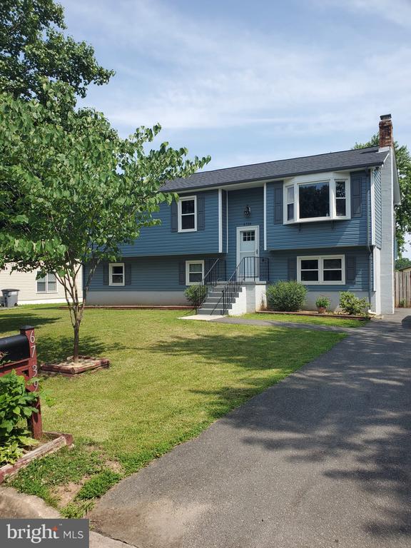  - bi-level home with a chimney and a front yard