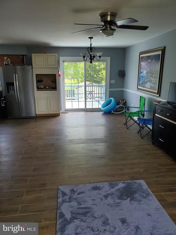  - living area with a ceiling fan, dark wood-style floors, and a chandelier