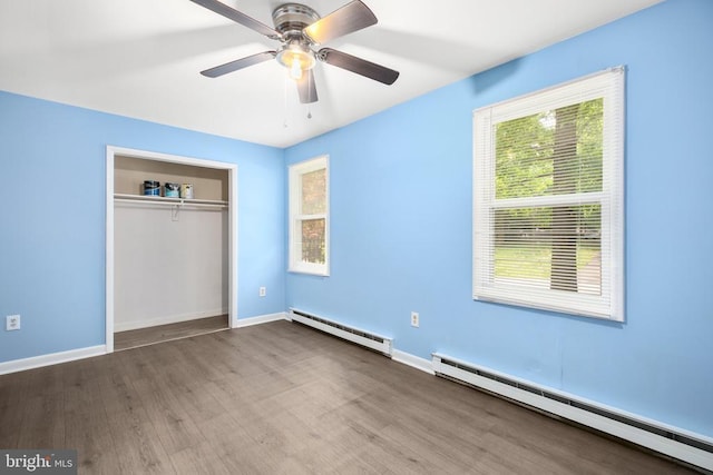 221 Hampton Dr, Spotsylvania, VA 22551 - unfurnished bedroom featuring a baseboard heating unit, multiple windows, and wood finished floors