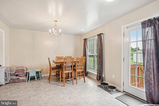  - dining room featuring a chandelier and baseboards