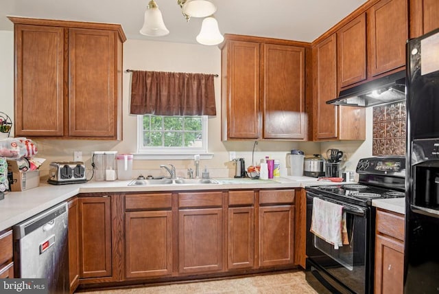  - kitchen featuring black appliances, under cabinet range hood, light countertops, and brown cabinets