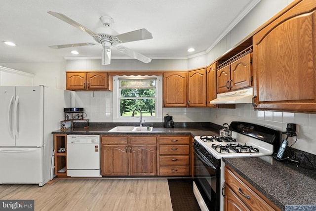  - kitchen featuring white appliances, under cabinet range hood, brown cabinetry, light wood-style flooring, and decorative backsplash