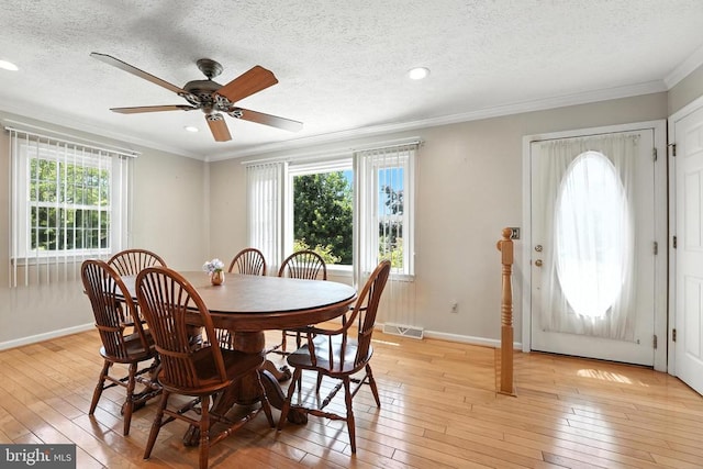  - dining area with healthy amount of natural light, light wood-style flooring, ornamental molding, a textured ceiling, and ceiling fan