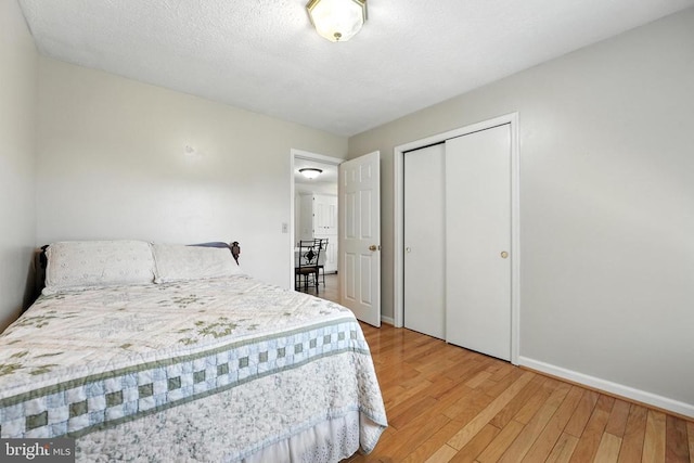  - bedroom featuring wood finished floors and a closet