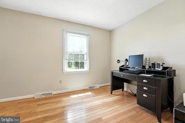  - office area with light wood-style flooring and a textured ceiling