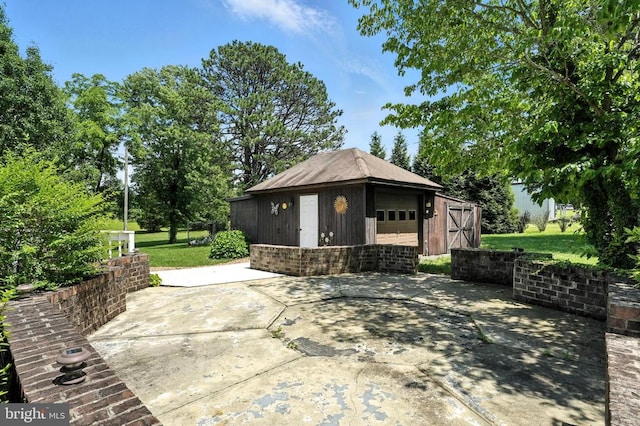  - view of patio / terrace featuring an outbuilding
