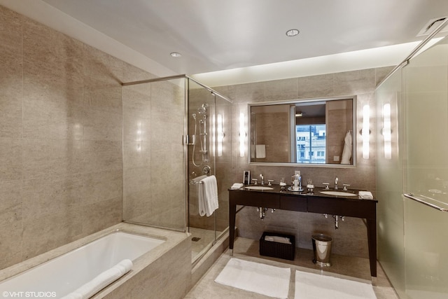 bathroom featuring tile walls, separate shower and tub, double vanity, and tile floors