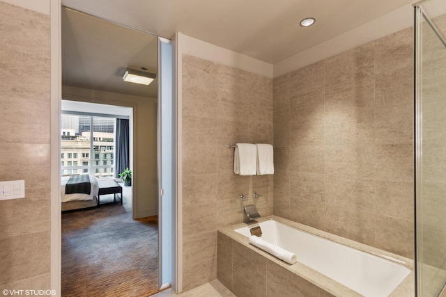 bathroom with a relaxing tiled bath