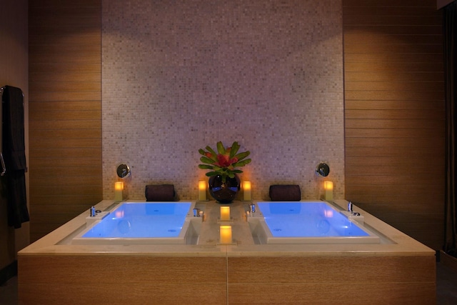 bathroom featuring a washtub and tile walls