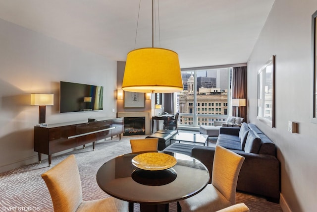 dining area featuring light carpet and a wall of windows