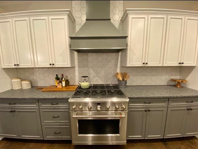 kitchen featuring backsplash, stainless steel range, dark wood-type flooring, and custom exhaust hood