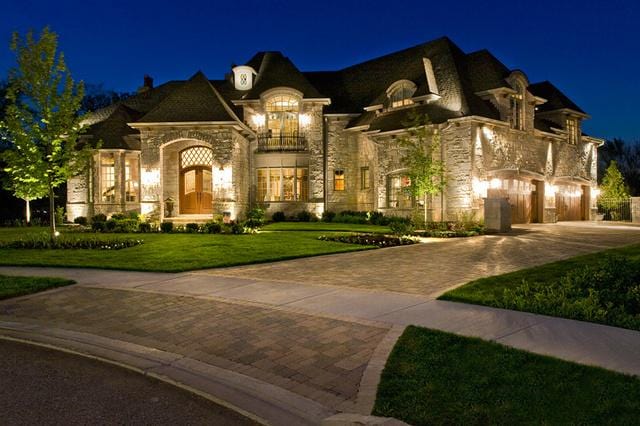 french country style house featuring a balcony and a lawn