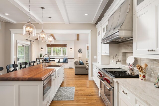 7S410 Arbor Dr, Naperville, IL 60540 - kitchen with custom exhaust hood, tasteful backsplash, white cabinets, range with two ovens, and light wood-type flooring