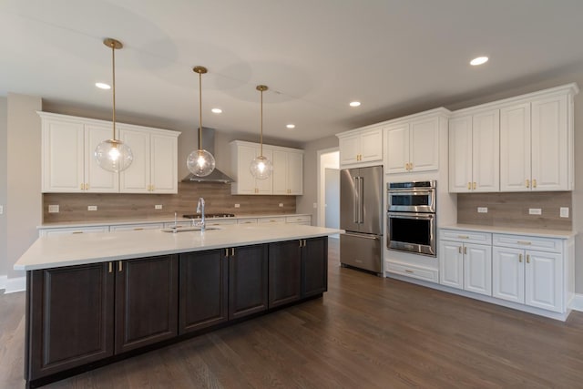 kitchen featuring white cabinets, dark hardwood / wood-style flooring, stainless steel appliances, and wall chimney exhaust hood