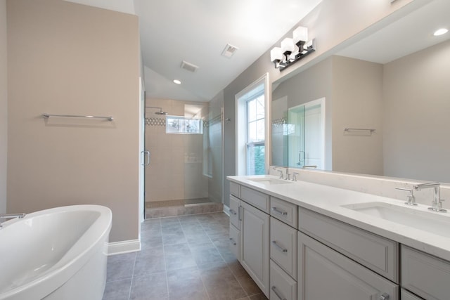 bathroom with tile flooring, double sink, independent shower and bath, and vanity with extensive cabinet space