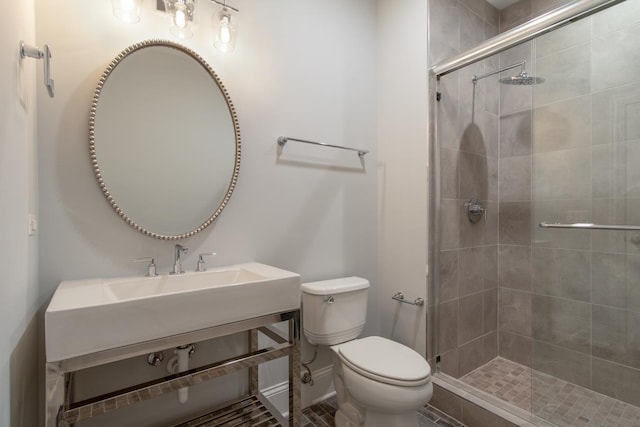 bathroom featuring a shower with shower door and toilet