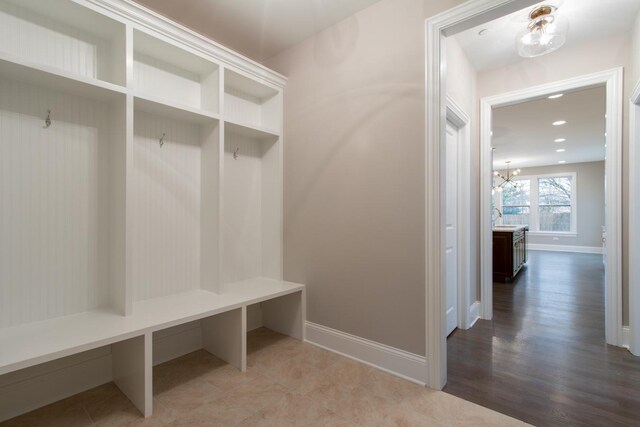 mudroom with tile floors and a notable chandelier