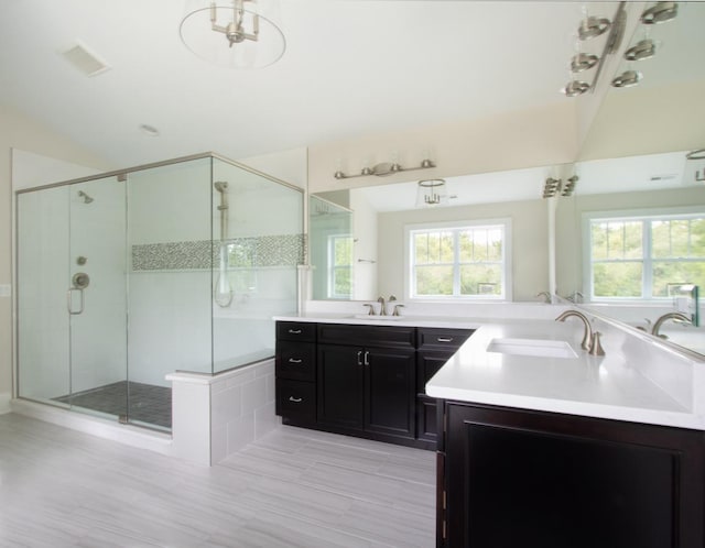 bathroom featuring an enclosed shower, double sink, and oversized vanity