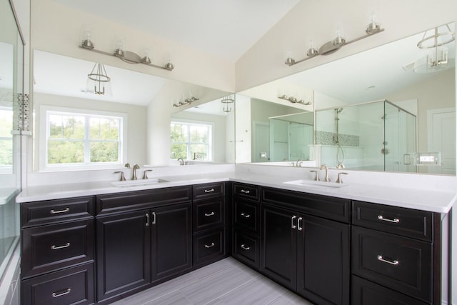 bathroom with walk in shower, double sink, vaulted ceiling, tile flooring, and large vanity