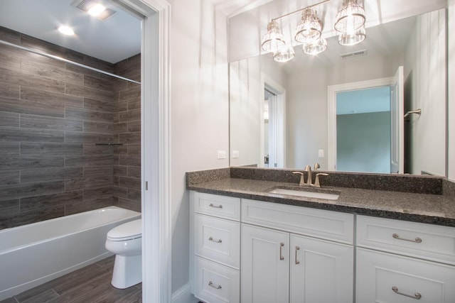 full bathroom with tiled shower / bath, toilet, and vanity with extensive cabinet space